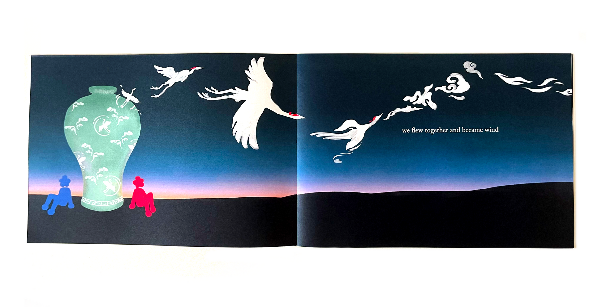 A spread of pages from sea and sky zine. Two figures, one red and one blue, with flower shaped heads sit side by side a celadon vase decorated with cranes and clouds. Against the sunrise, cranes fly out of the vase and into the sky. The text reads, "we flew together and became wind." sea and sky zine is about community found through dreams and the fold over of past, present, and future.